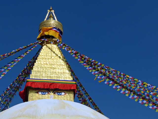 009.jpg - 009 Stupa Boudhanath jest dla tybetańskich buddystów najświętszym miejscem poza Tybetem. Potężna kopuła ma około 35 metrów średnicy, co czyni ją największą w Nepalu i jedną z największych na świecie. Pomiędzy oczami znajduje się coś w rodzaju nosa - jest to znak jedności.