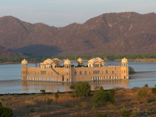 195.jpg - 195 Pałac na wodzie Jal Mahal pośrodku jeziora Man Sagar w Jaipur. Jal Mahal znaczy dosłownie wodny pałac. Jezioro Man Sagar powstało pod koniec XVI wieku – wcześniej była tu naturalna depresja. Król Amer zdecydował się stworzyć na niej tamę, by gromadziła wodę na czasy suszy dla okolicznej ludności. Wówczas istniał już pałac Jal Mahal, który został zalany. Budynek i otaczające go jezioro powiększył i odnowił w XVIII wieku Jai Singh II władca Amer. Pałac ma pięć pięter, ale cztery z nich ukryte są pod wodą. Najwyższe piętro jest za to w pełni wyeksponowane i można je oglądać. 