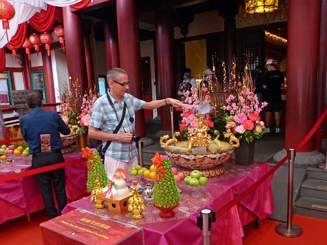 062.jpg - 062 Na znak szczęścia polewa się wodą Buddę. Na stołach przed wejściem dary w postaci owoców, kwiatów, kadzidełek itp.
