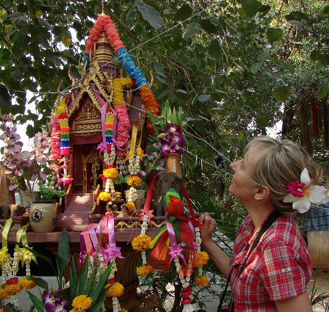 104.jpg - 104 Sala Phra Pum - domek dla duchów udekorowany girlandami kwiatów i porcelanowymi figurkami. Codziennie składane tu są dary w postaci jedzenia, aby przeprosić za najście zakłócające spokój duchom. W przypadku rezygnacji z tego azylu dla duchów można się spodziewać najgorszych nieszczęść.