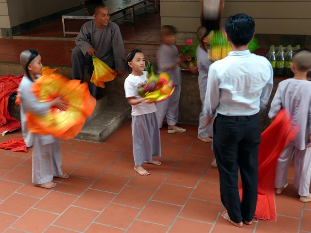 312.jpg - 312 Nauczyciel uczy dzieci tańca z szarfami i owocami przed Świętem Tet.